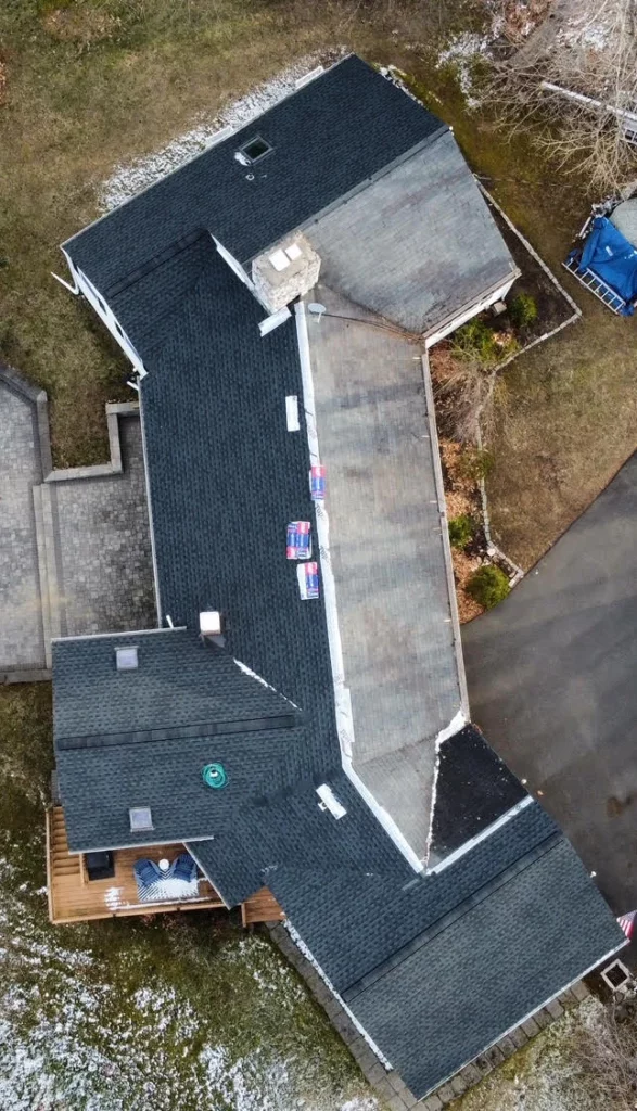 aerial view of a house with an almost finished roof shingles installations